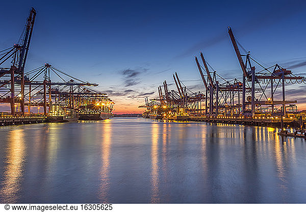 Germany  Hamburg  Port of Hamburg  Container Terminal  container cranes and container ships in the evening