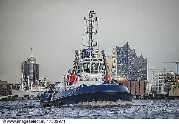 Germany  Hamburg  Tugboat on Elbe canal with Elbphilharmonie in background