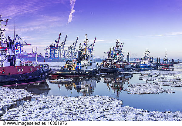 Germany  Hamburg  tugboats on icy Elbe river during sunrise