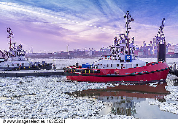 Germany  Hamburg  tugboats on icy Elbe river during sunrise