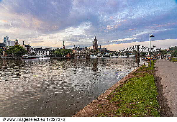 Germany  Hesse  Frankfurt  Riverbank promenade at dusk with Eiserner Steg bridge in background