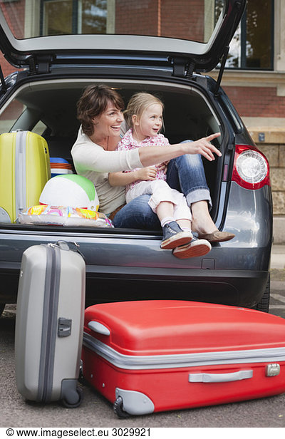 Germany  Leipzig  Mother and daughter (4-5) sitting in back of car  smiling  portrait