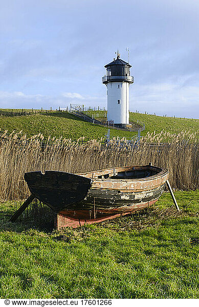Germany  Lower Saxony  Cuxhaven  Old rowboat wth reeds and Dicke Berta lighthouse in background