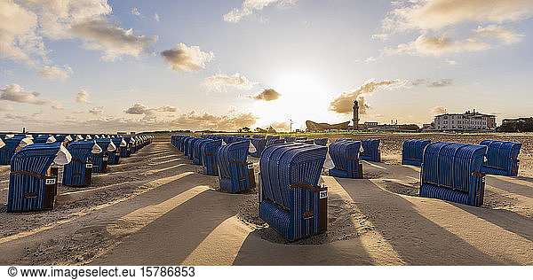 Germany  Mecklenburg-West Pomerania  Warnemunde  Hooded beach chairs on beach at sunset