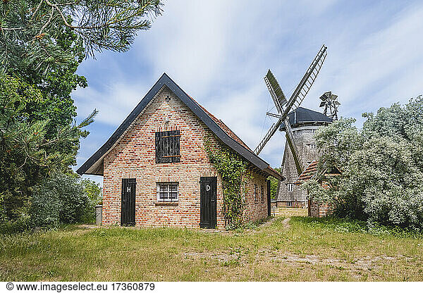 Germany  Mecklenburg-Western Pomerania  Benz  Brick house with old windmill in background