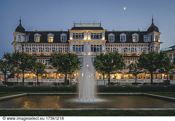 Germany  Mecklenburg-Western Pomerania  Heringsdorf  Fountain splashing in front of luxury hotel at dusk