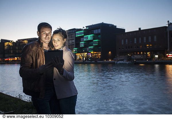 Germany  Muenster  couple taking a selfie with digital tablet at the harbour