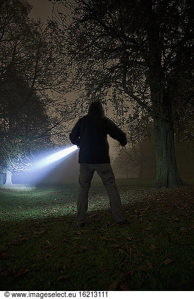 Germany  Munich  Young man with torch in foggy night