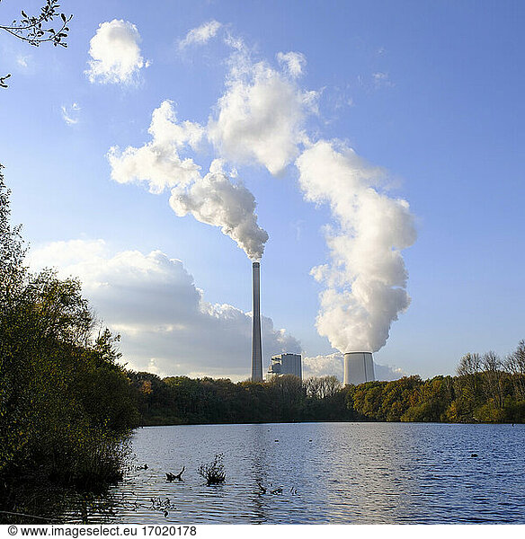 Germany  North Rhine-Westphalia  Bergkamen  River in Beversee nature reserve with smoke rising from coal-fired power station in background