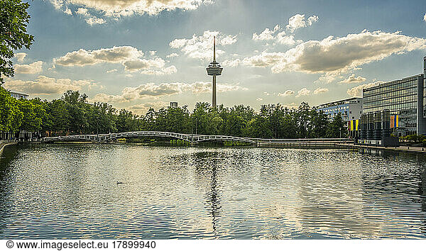 Germany  North Rhine-Westphalia  Cologne  MediaPark lake at dusk with Colonius tower in background