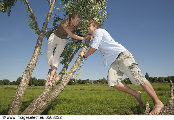 Germany  North Rhine Westphalia  Duesseldorf  Couple playing with tree  smiling