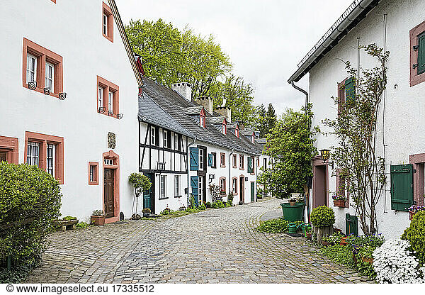 Germany  North Rhine-Westphalia  Kronenburg  Row of rustic houses along cobblestone street in historic medieval village