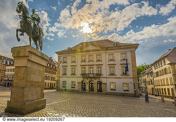 Germany  Rhineland-Palatinate  Landau  Sun setting over town hall with equestrian statue in foreground