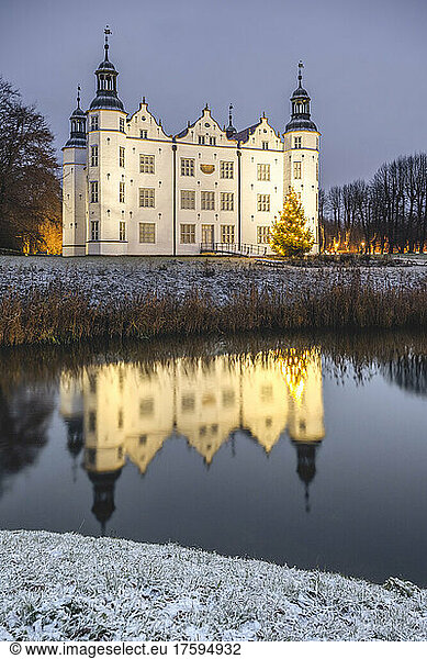 Germany  Schleswig-Holstein  Ahrensburg  Schloss Ahrensburg reflecting in nearby pond at dusk