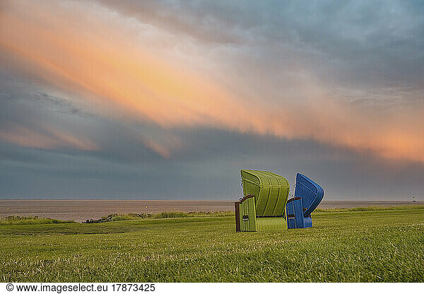 Germany  Schleswig-Holstein  Pellworm  Two hooded beach chairs at dusk