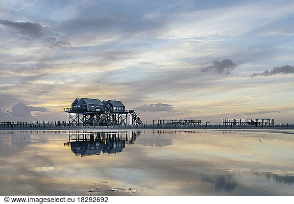 Germany  Schleswig-Holstein  St. Peter-Ording  Clouds over coastal stilt houses at dusk