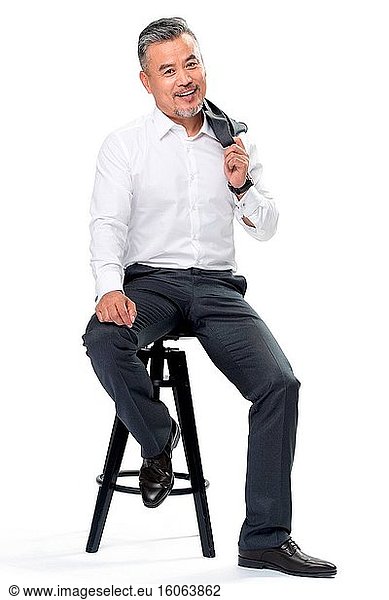Geschäftlich tätiger Mann mittleren Alters in einem Anzug auf einem Stuhl