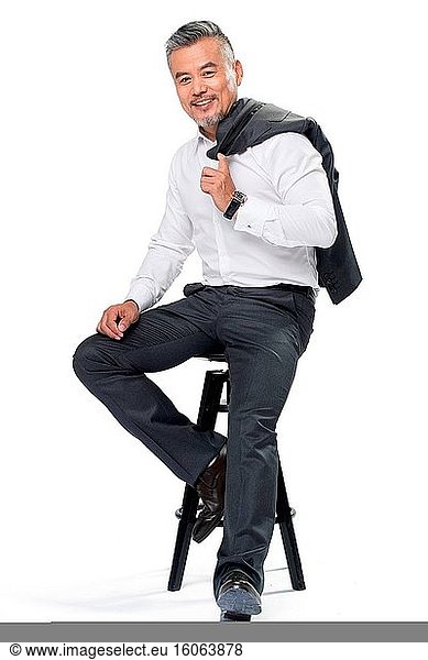 Geschäftlich tätiger Mann mittleren Alters in einem Anzug auf einem Stuhl