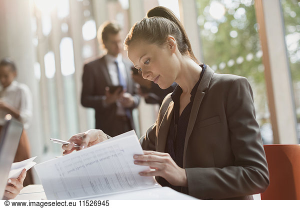 Geschäftsfrau beim Lesen von Papierkram