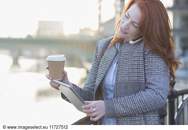 Geschäftsfrau beim Multitasking  beim Kaffeetrinken und beim Telefonieren mit dem Handy
