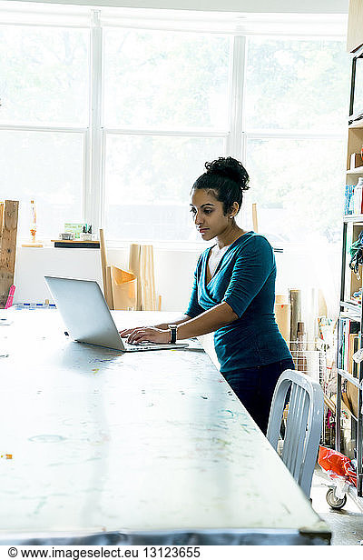 Geschäftsfrau benutzt Laptop-Computer  während sie im Büro am Tisch sitzt