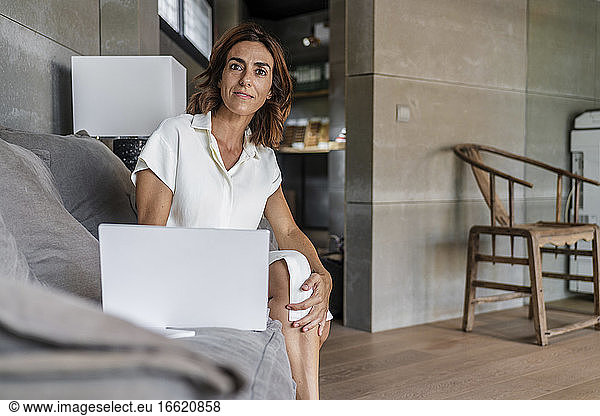 Geschäftsfrau  die einen Laptop benutzt  während sie im Büro am Laptop sitzt