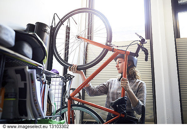 Geschäftsfrau entfernt Fahrrad vom Ständer im Kreativbüro