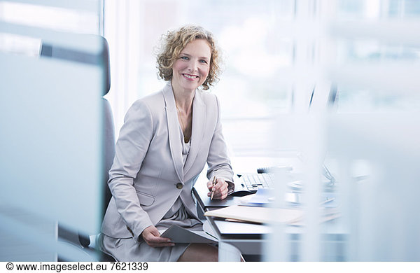 Geschäftsfrau lächelt am Schreibtisch