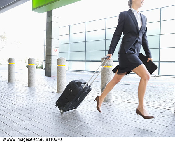Geschäftsfrau läuft mit Koffer