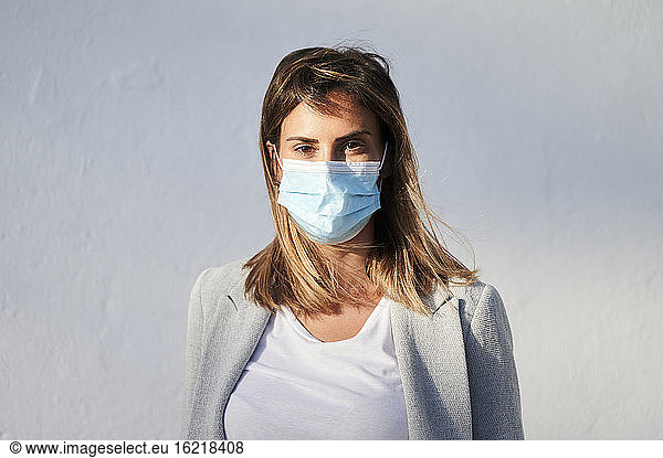 Geschäftsfrau mit Gesichtsschutzmaske während COVID-19