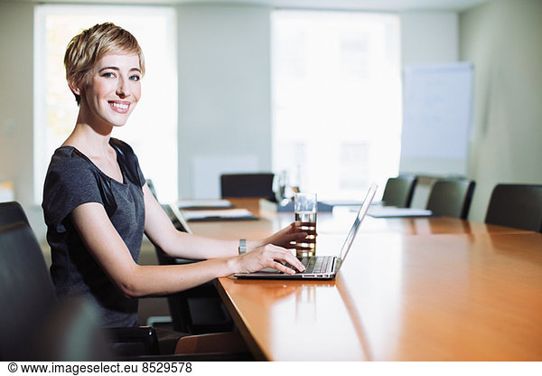 Geschäftsfrau mit Laptop am Konferenztisch