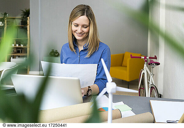 Geschäftsfrau sitzt mit Papier im Büro