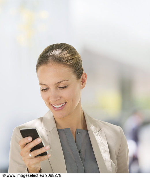 Geschäftsfrau SMS mit Handy im Freien