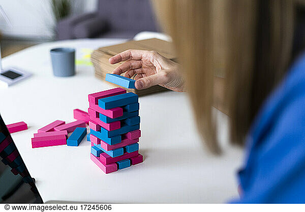 Geschäftsfrau spielt im Büro ein Spiel zum Entfernen von Blöcken