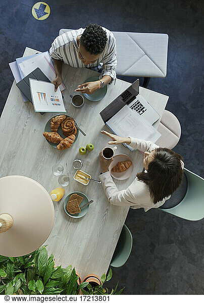 Geschäftsfrauen besprechen Papierkram beim Frühstückstreffen im Büro