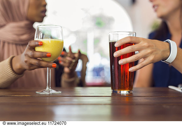Geschäftsfrauen  die sich unterhalten und Saft trinken