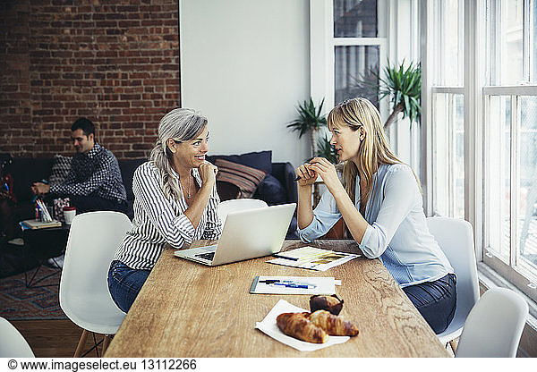 Geschäftsfrauen diskutieren am Konferenztisch im Kreativbüro