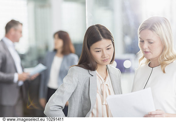 Geschäftsfrauen diskutieren Papierkram im Büro