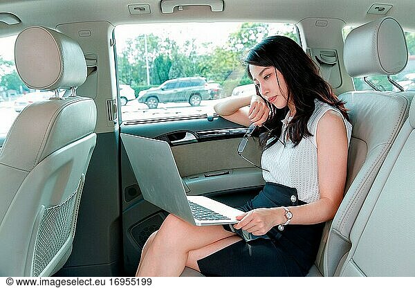 Geschäftsfrauen in den Autos  die den Computer benutzen