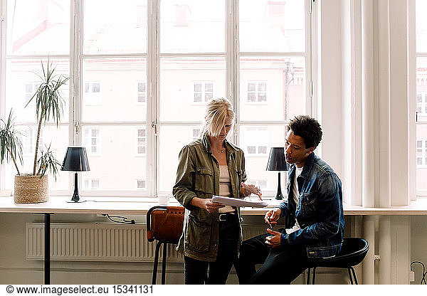 Geschäftskollegen besprechen Dokument während ihrer Arbeit im Büro