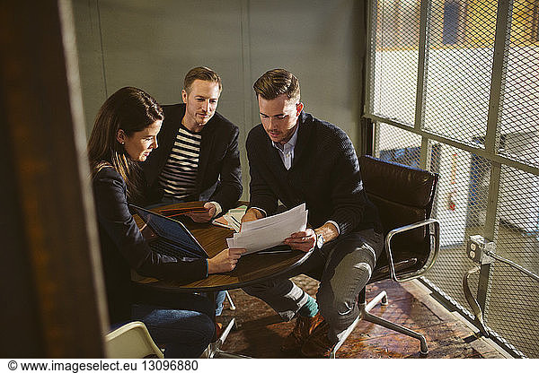 Geschäftsleute besprechen Dokumente bei Tisch im Büro