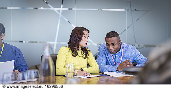 Geschäftsleute besprechen Papierkram in Konferenzraumbesprechung