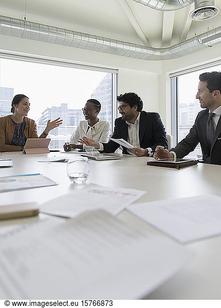 Geschäftsleute  die in einem Konferenzraum Papierkram besprechen