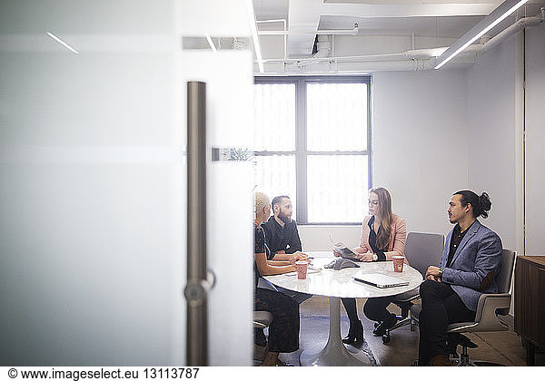 Geschäftsleute diskutieren während sie im Büro sitzen