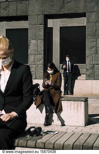 Geschäftsleute mit Gesichtsmasken halten soziale Distanz