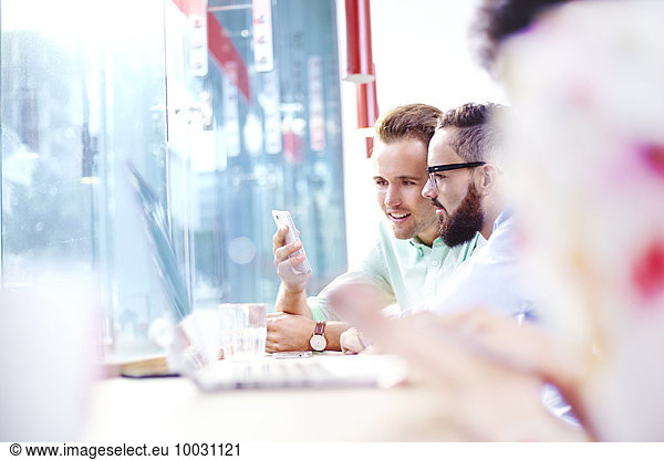 Geschäftsleute SMS mit Handy im Café