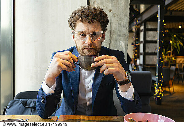 Geschäftsmann im Anzug bei einer Tasse Kaffee im Café