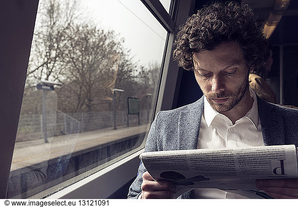 Geschäftsmann liest Zeitung im Zug