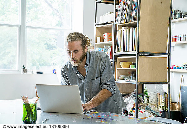 Geschäftsmann mit Laptop-Computer am Tisch im Büro