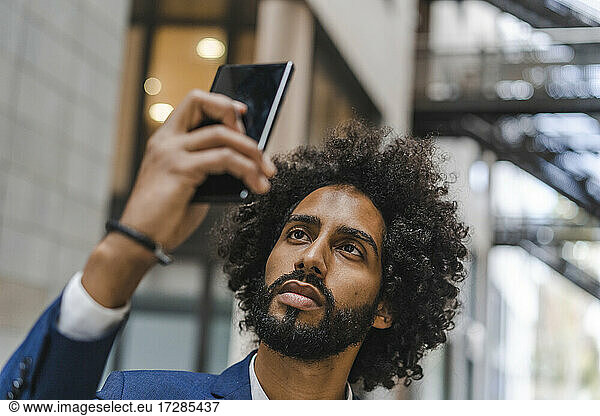 Geschäftsmann nimmt Selfie durch Smartphone